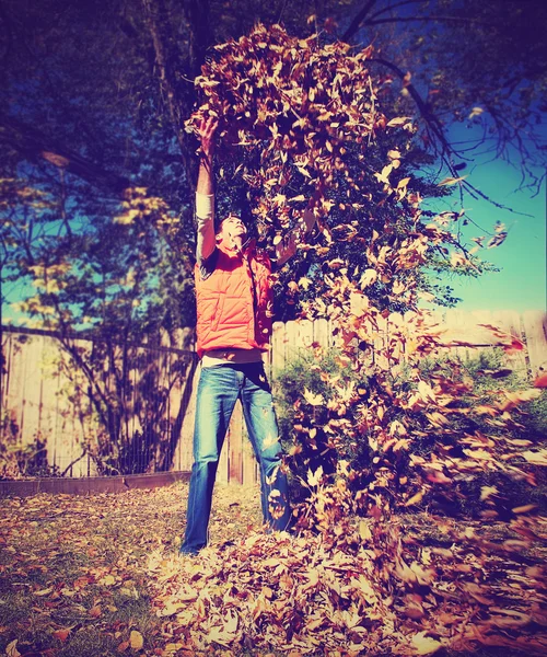 L'homme jetant des feuilles dans l'air — Photo