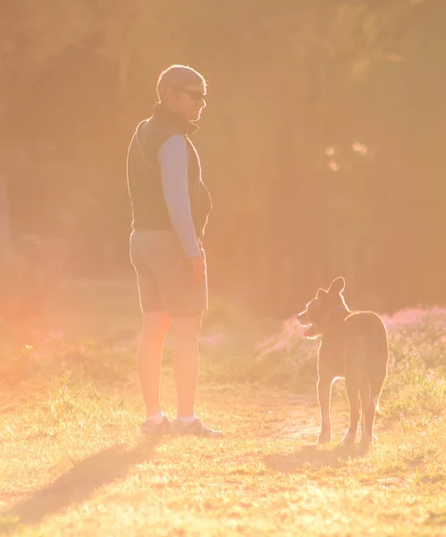 Frau geht mit Hund spazieren — Stockfoto