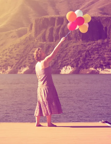 Kadın üstünde rıhtım balonlar ile — Stok fotoğraf