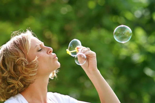 Mooie vrouw waait bubbels — Stockfoto