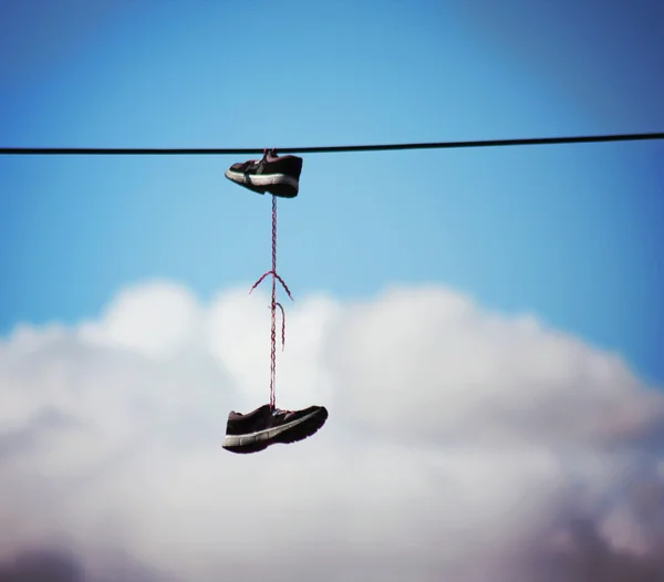 Old Shoes hanging on electrical wire against a blue sky Stock Photo by ...