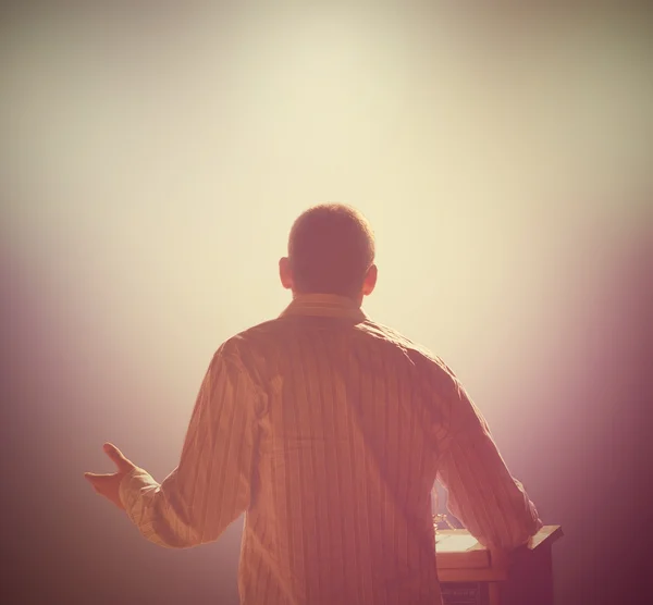 Man in front of podium and audience — Stock Photo, Image