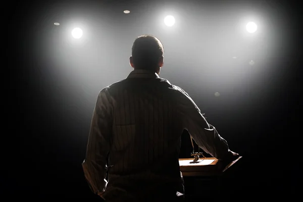 Homme devant le podium et le public — Photo