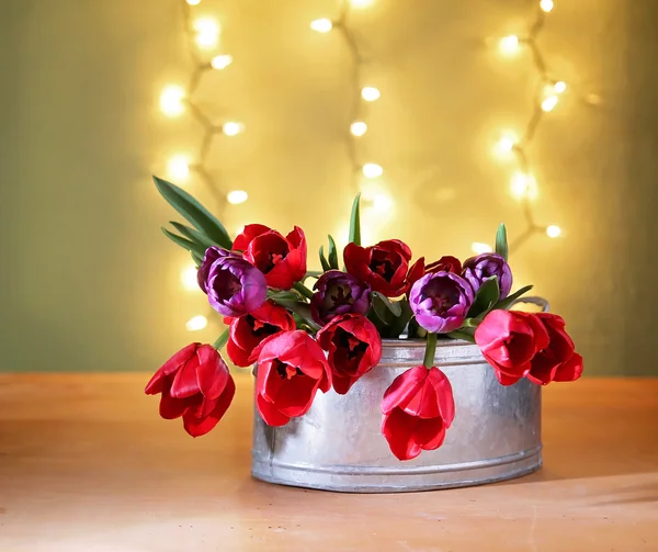 Tulips on a wooden board in front of bokeh. — Stock Photo, Image