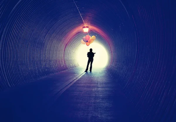 Girl at tunnel holding balloons — Stock Photo, Image
