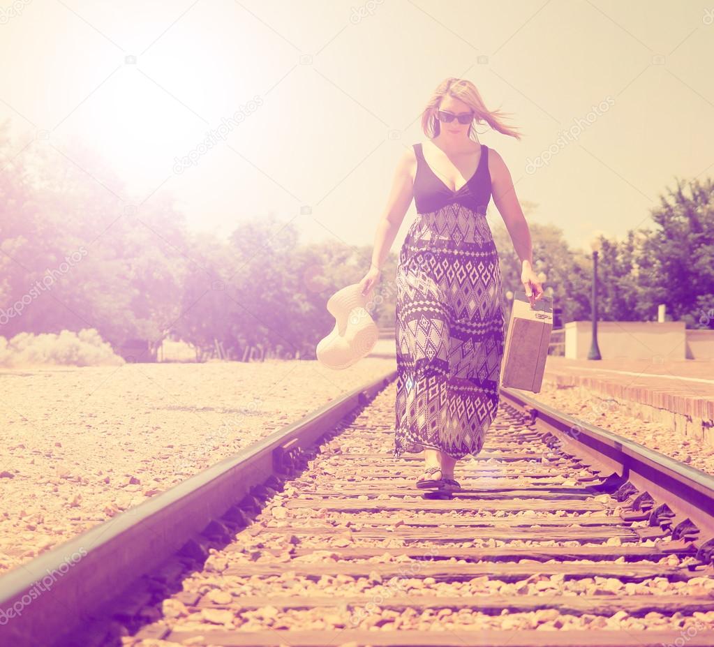 Girl walking down train tracks