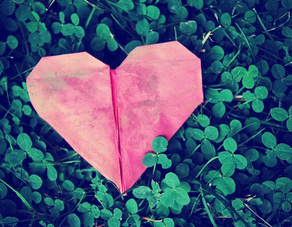 Corazón de origami sobre trébol verde —  Fotos de Stock