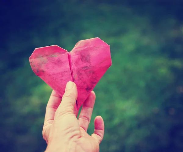 Origami kalp tutan el — Stok fotoğraf