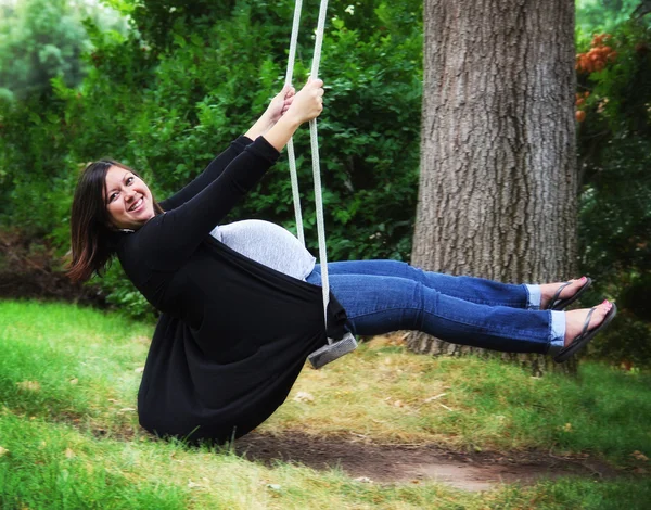 Pregnant woman on a swing — Stock Photo, Image