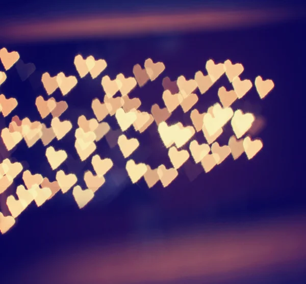 A nice background with defocused lights blurred into the shape of hearts good for holidays like valentine's day or wedding announcements or romantic cards — Stock Photo, Image