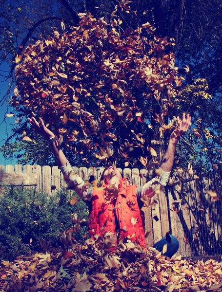 Hombre jugando en hojas de otoño —  Fotos de Stock