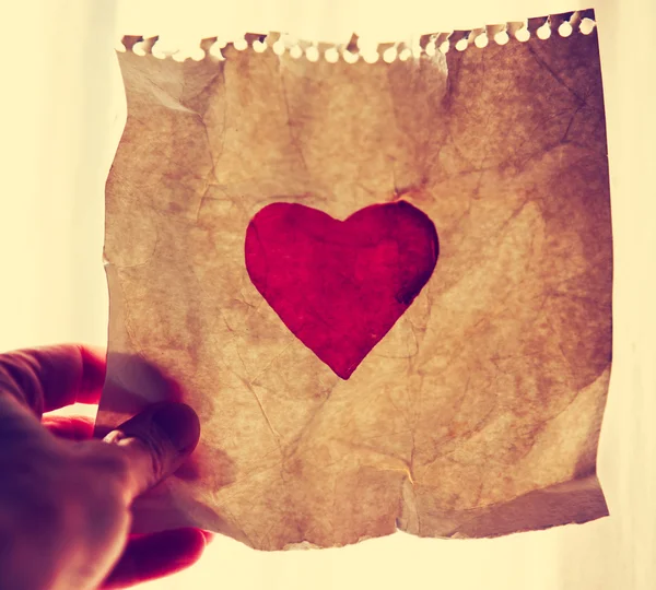 Hand holding painted paper heart — Stock Photo, Image