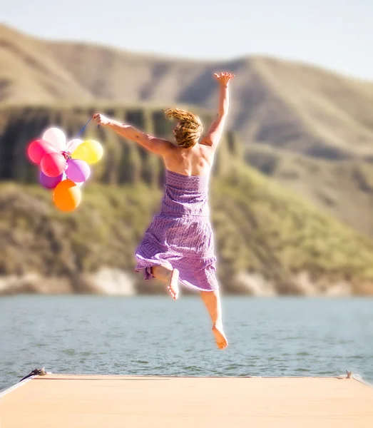 Femme sautant avec des ballons — Photo