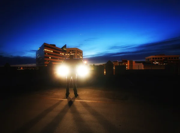 Car headlights with a person — Stock Photo, Image