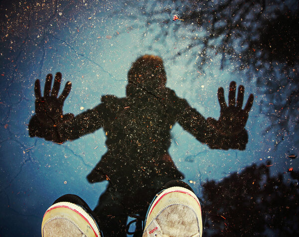 Person with a reflection is a puddle Royalty Free Stock Images