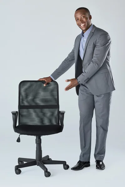 Hombre de negocios apunta a la silla de oficina vacía —  Fotos de Stock