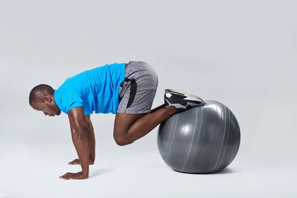 Hombre haciendo rutina de ejercicios de núcleo en pelota de gimnasio — Foto de Stock