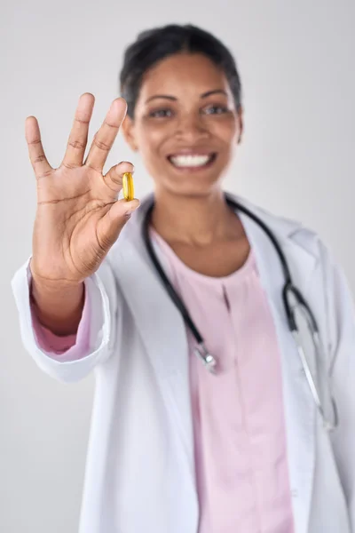 Sonriente asiático médico en estudio holding medicina píldora — Foto de Stock