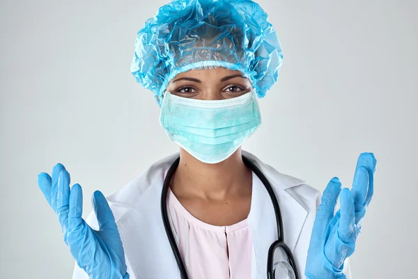 Счастливая женщина-хирург в маске и перчатках — стоковое фото