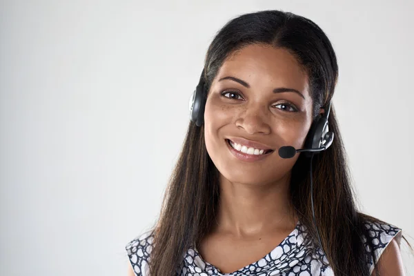 Kulaklıklı mikrofon seti ile gülümseyen karışık ırk kadın — Stok fotoğraf