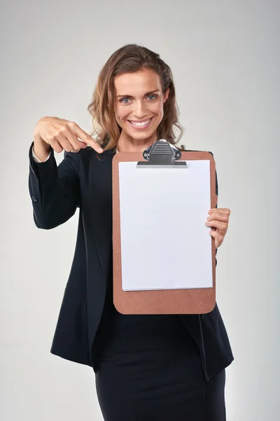 Smiling woman pointing to empty poster — Stock Photo, Image