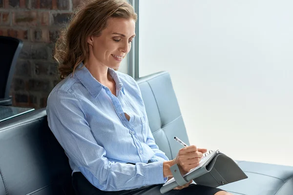 Geschäftsfrau schreibt entspannt in ihr Tagebuch — Stockfoto