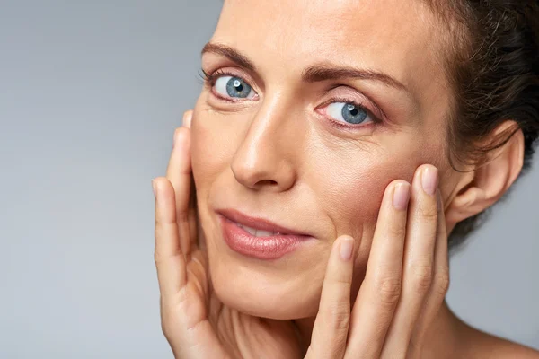 Skin care with middle age woman in studio — Stock Photo, Image