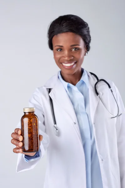 Woman doctor holding up a pill vitamin — Stock Photo, Image