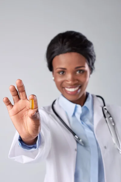 Médico sonriente sosteniendo píldora medicina — Foto de Stock