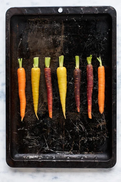 Colourful carrots on old baking pan — Stock Photo, Image