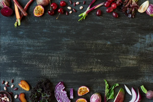 Border of fruits and vegetables on dark background