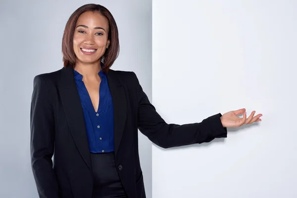 Atractiva mujer de negocios señalando y sonriendo — Foto de Stock