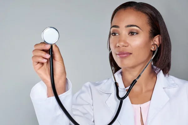 Mujer médico usando su estetoscopio — Foto de Stock