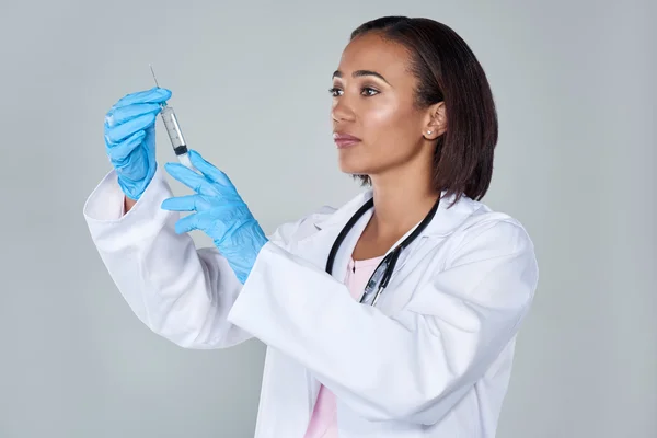 Médico femenino sosteniendo una jeringa inyectable — Foto de Stock