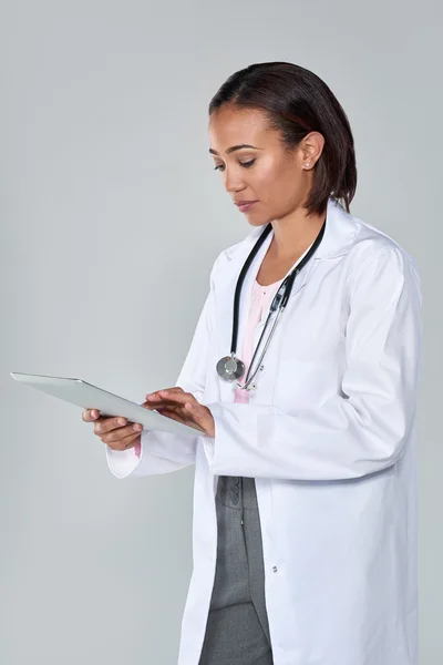 Женщина врач с помощью планшетного устройства — стоковое фото