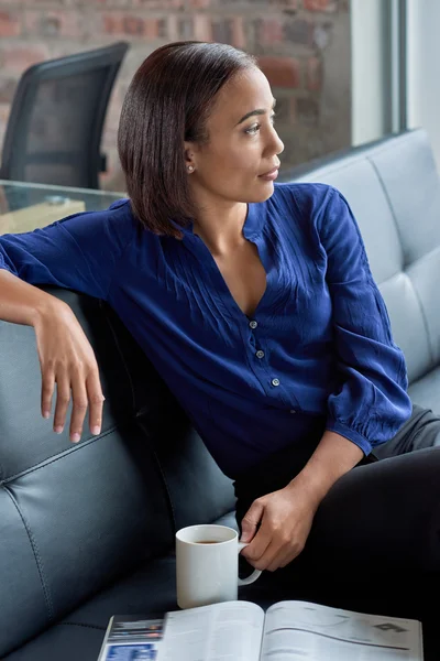 Exitosa mujer de negocios pensando en sofá con café —  Fotos de Stock