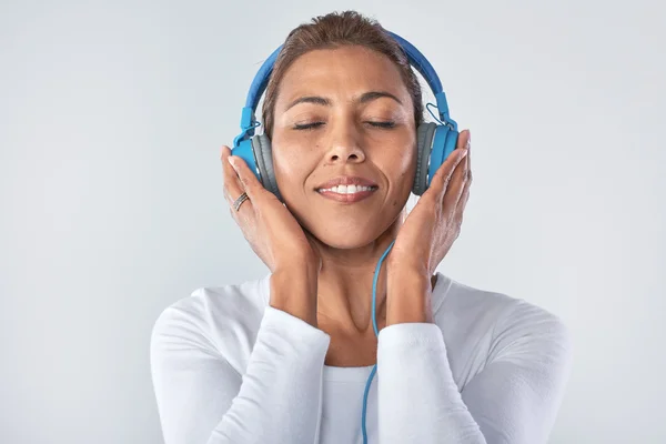 Mujer de raza mixta con auriculares azules — Foto de Stock