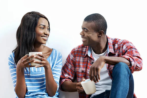 African couple on floor with coffee — Stock Photo, Image