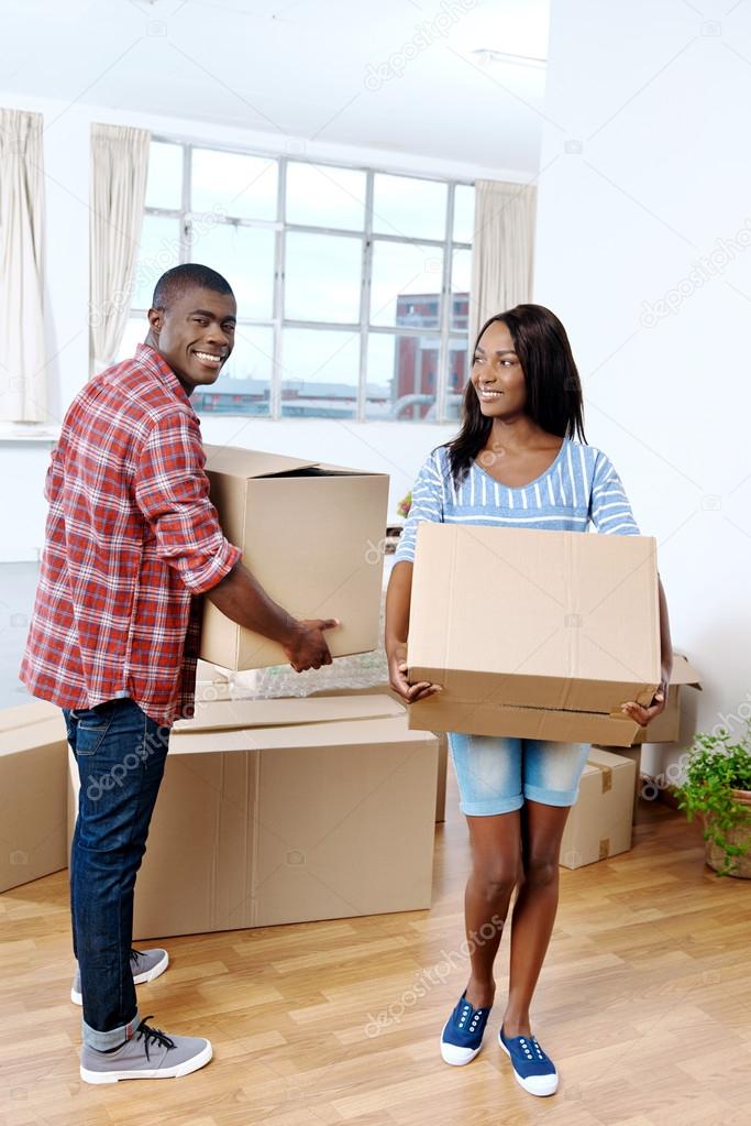 african couple moving boxes into new home