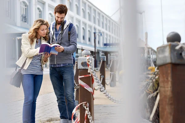 Couple with guide book on vacation — Stock Photo, Image