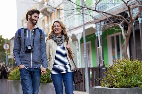 Couple walking with camera in city — Stock Photo, Image