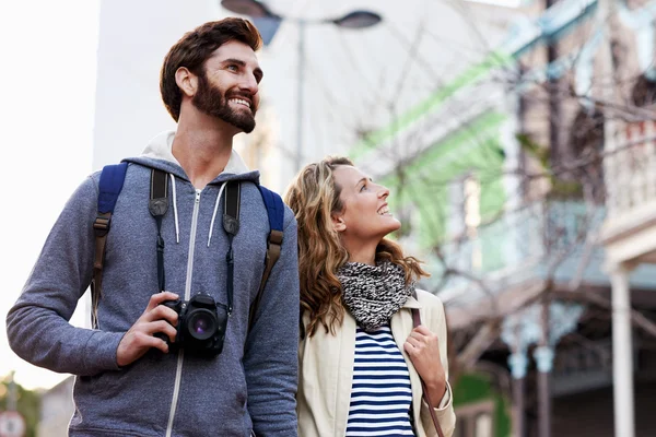 Couple walking with camera in city — Stock Photo, Image