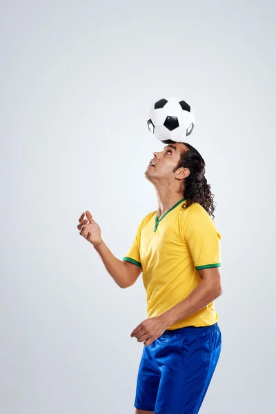 Fútbol jugador balanceo pelota de fútbol — Foto de Stock