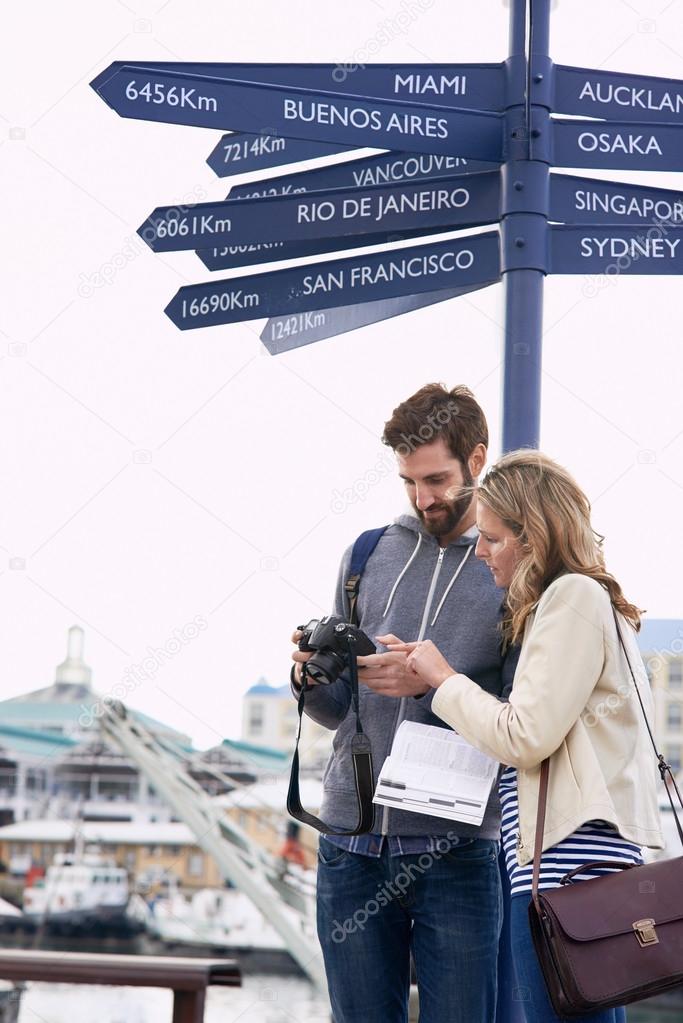 Couple on travel holiday at sign