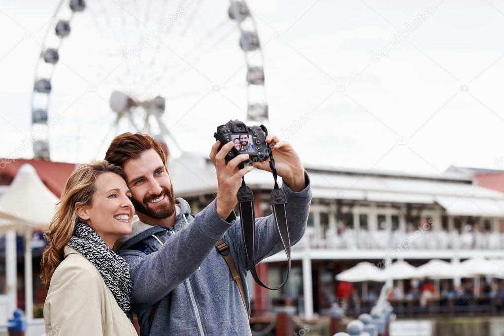 Couple taking selfie at ferris wheel