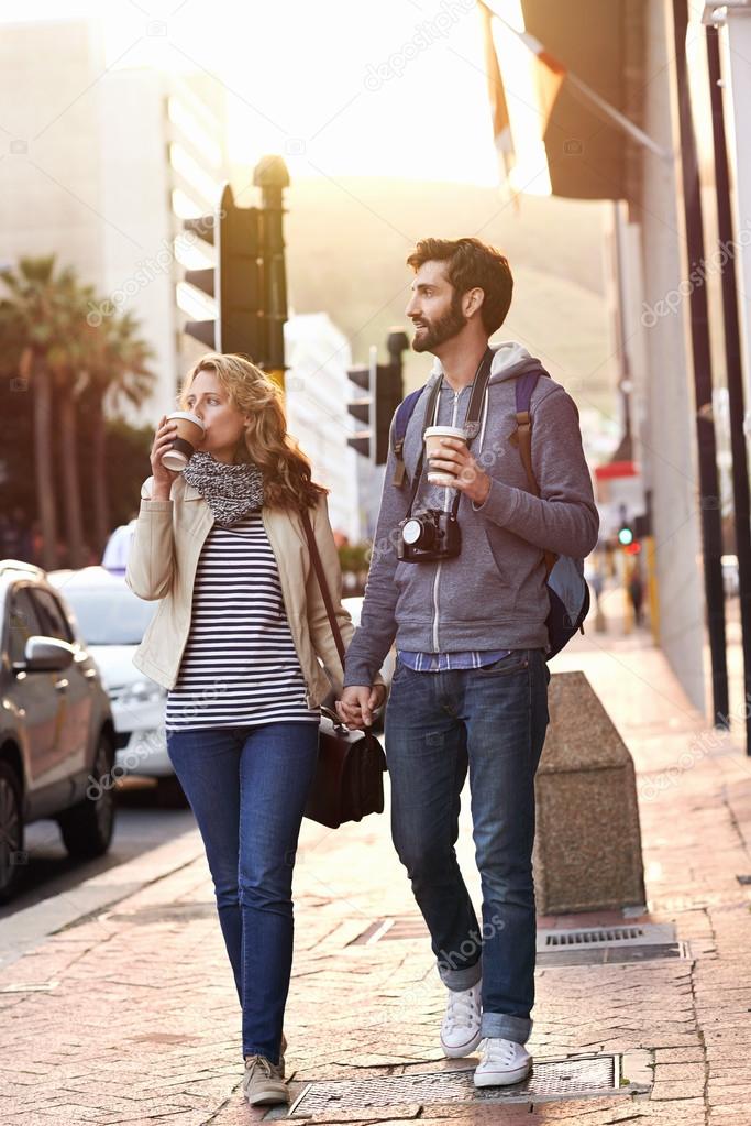 Tourist couple with coffee walk