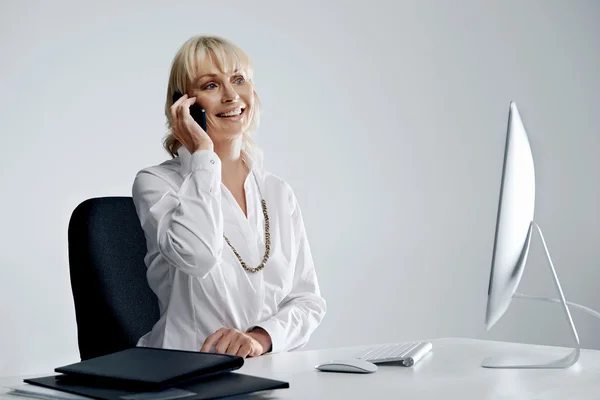Biznes kobieta przy biurku mówiąc na telefon — Zdjęcie stockowe