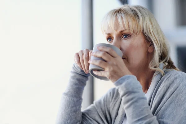 Femme blonde sirotant une tasse de thé — Photo