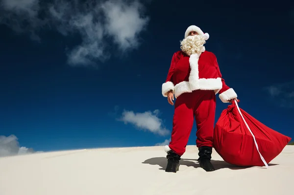 Noel Baba bir kumsalda ayakta — Stok fotoğraf