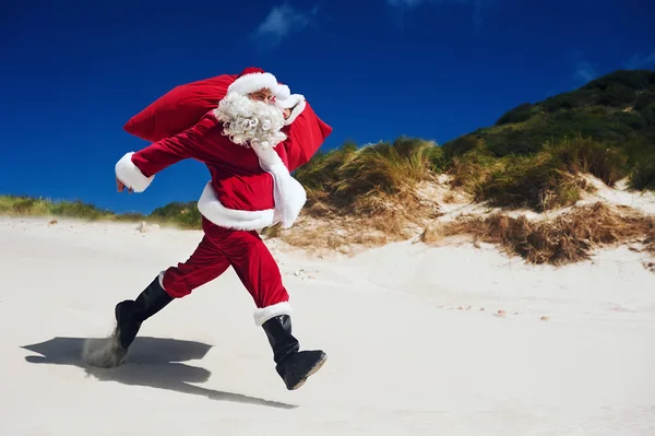 Santa Claus wandelen langs het strand — Stockfoto